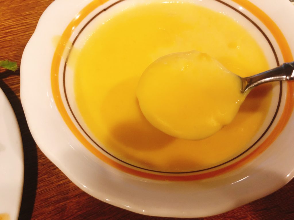 ステーキのあさくまのコーンスープをスプーンですくった写真