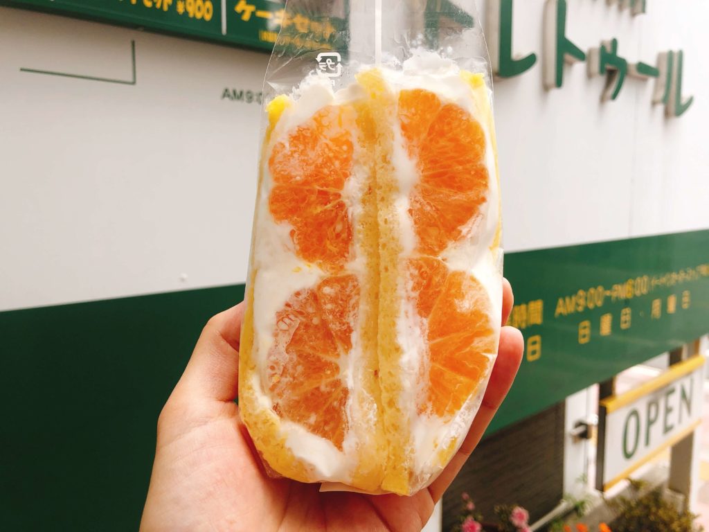 トレトゥールのフルーツサンド（オレンジ）を看板の前で撮影